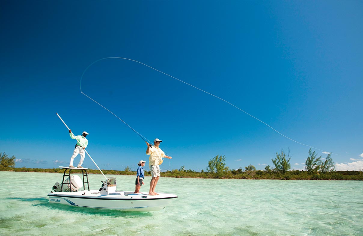 A couple bonefishing from a boat in the shallows of Eleuthera